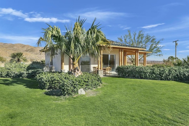 rear view of house with a yard and a mountain view