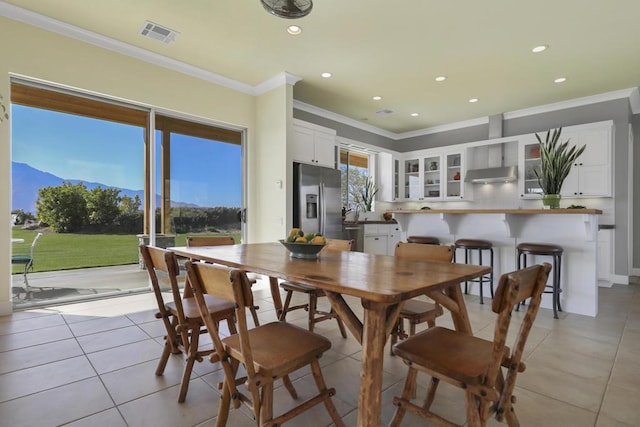 tiled dining area with ornamental molding and a mountain view