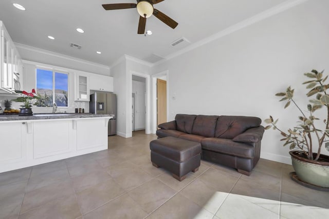 living room featuring ornamental molding, sink, light tile patterned floors, and ceiling fan