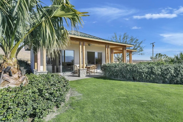 rear view of property featuring a yard and a patio