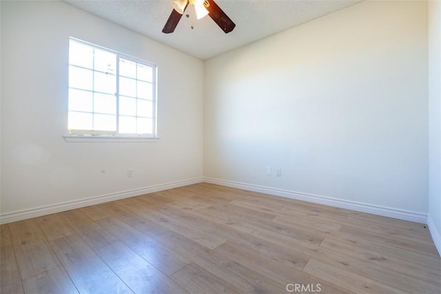 spare room featuring ceiling fan and light hardwood / wood-style flooring