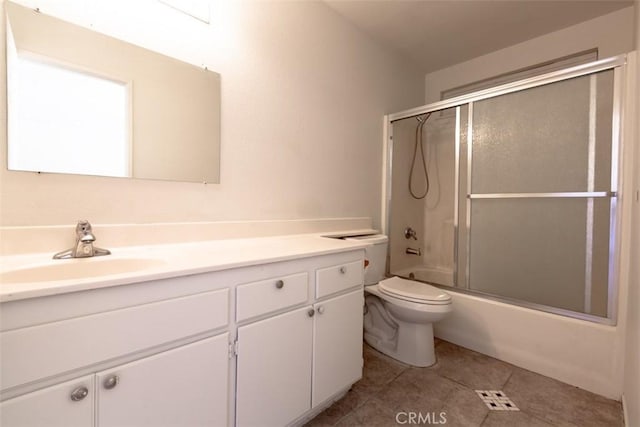 full bathroom featuring toilet, bath / shower combo with glass door, tile patterned flooring, and vanity