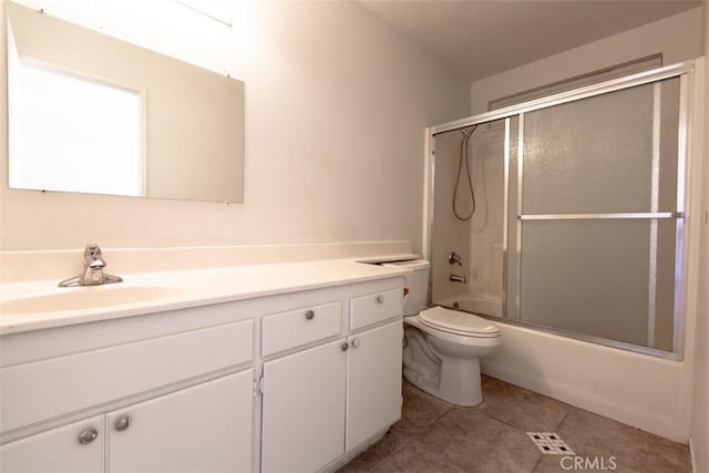 bathroom with shower / bath combination with glass door, vanity, toilet, and tile patterned floors