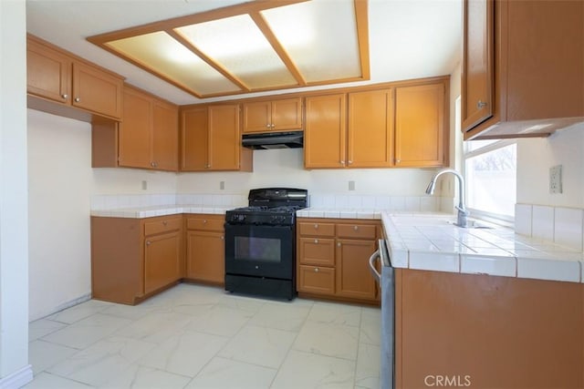 kitchen with black gas range, tile countertops, stainless steel dishwasher, and sink