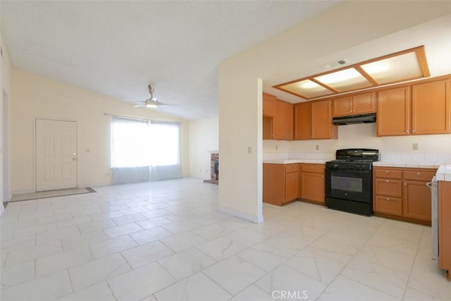 kitchen with ceiling fan, lofted ceiling, black range with gas stovetop, and tile countertops