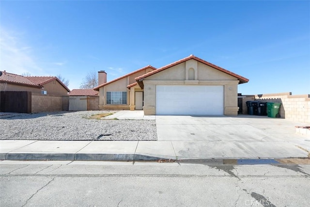 view of front of house with a garage, driveway, fence, and stucco siding