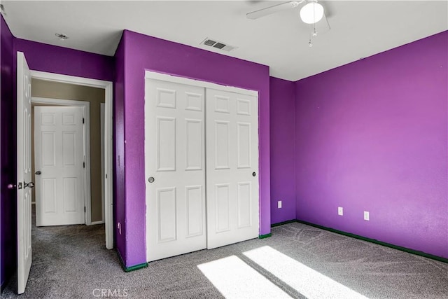 unfurnished bedroom featuring ceiling fan, a closet, and carpet