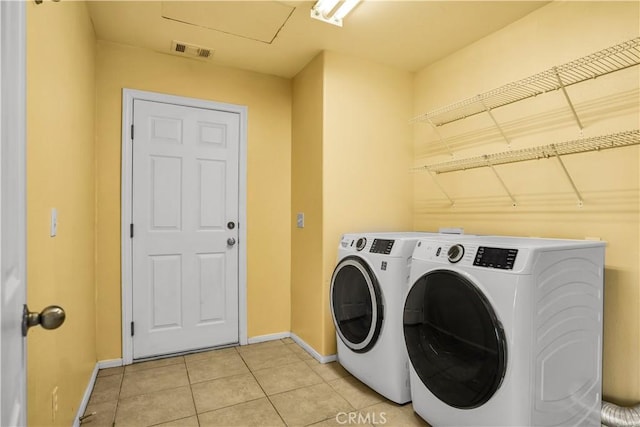 laundry area featuring separate washer and dryer and light tile patterned flooring