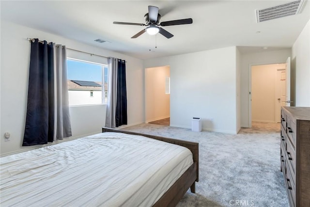 bedroom with baseboards, a ceiling fan, visible vents, and light colored carpet