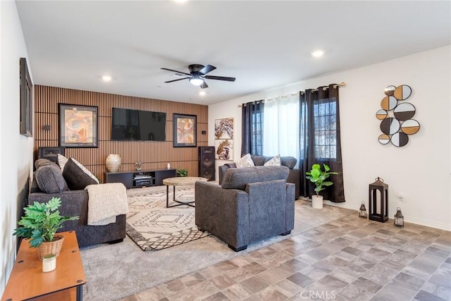 living area featuring an accent wall, recessed lighting, ceiling fan, and baseboards