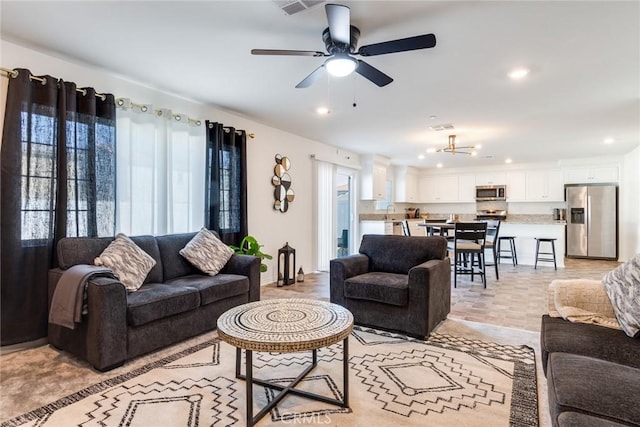 living room featuring visible vents, a ceiling fan, and recessed lighting