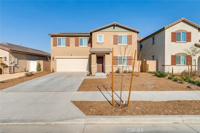 view of front of property featuring a garage, concrete driveway, and stucco siding