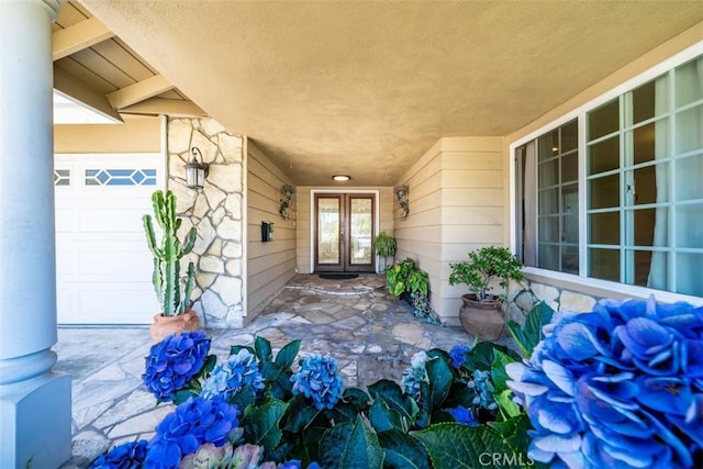 property entrance with a garage and french doors