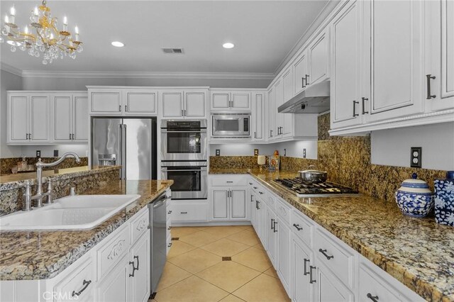 kitchen featuring pendant lighting, sink, crown molding, white cabinetry, and stainless steel appliances