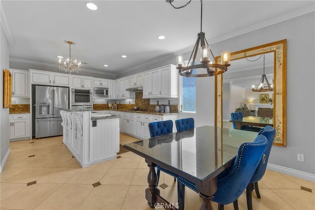 kitchen featuring a center island, hanging light fixtures, appliances with stainless steel finishes, ornamental molding, and white cabinets