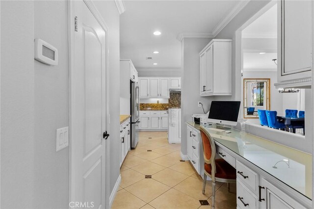 kitchen featuring white cabinets, tasteful backsplash, stainless steel refrigerator, light tile patterned flooring, and crown molding