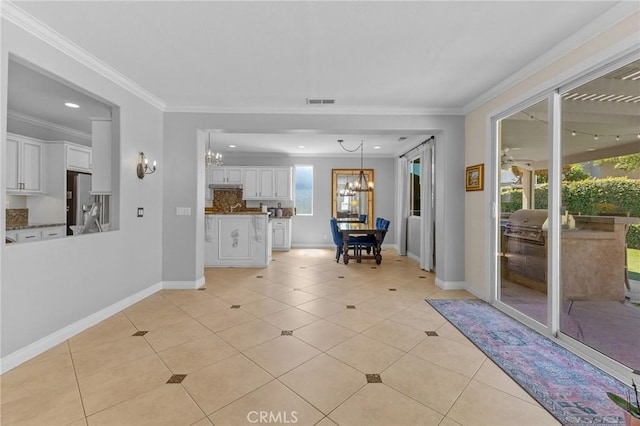 interior space with an inviting chandelier, crown molding, and light tile patterned flooring