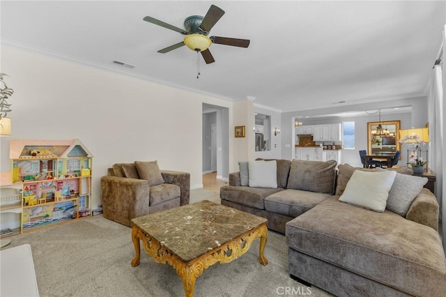 carpeted living room featuring crown molding and ceiling fan with notable chandelier