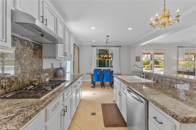 kitchen with appliances with stainless steel finishes, pendant lighting, white cabinets, and sink