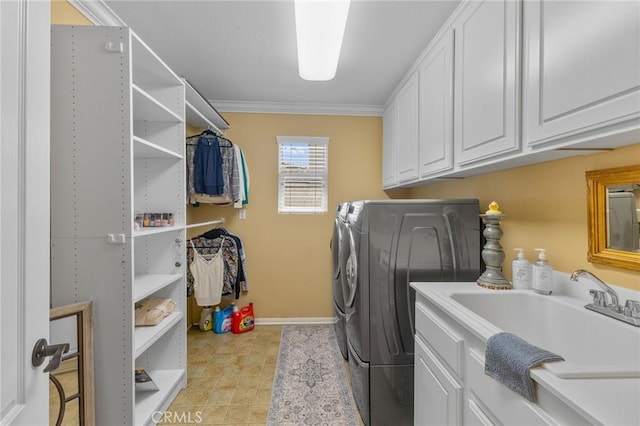 washroom with washing machine and dryer, cabinets, crown molding, and sink