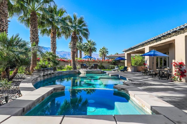 view of swimming pool with a mountain view and a patio area