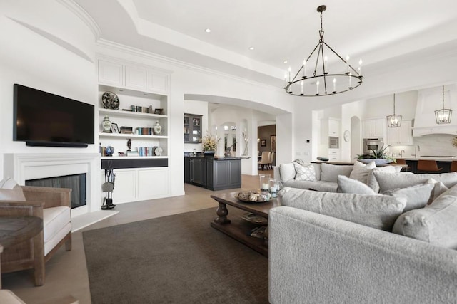 living room featuring a tray ceiling and built in shelves