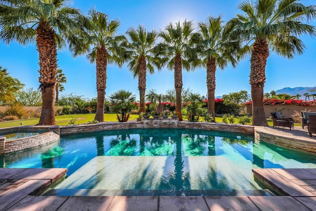 view of swimming pool with an in ground hot tub and a mountain view