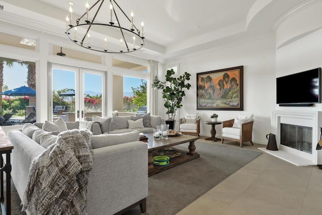 living room with a raised ceiling, concrete flooring, and an inviting chandelier