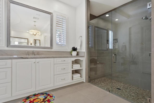 bathroom featuring a shower with door, vanity, and tile patterned floors