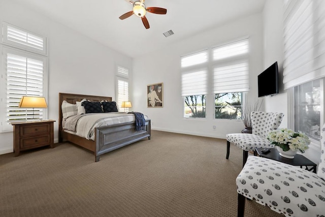 carpeted bedroom featuring multiple windows and ceiling fan