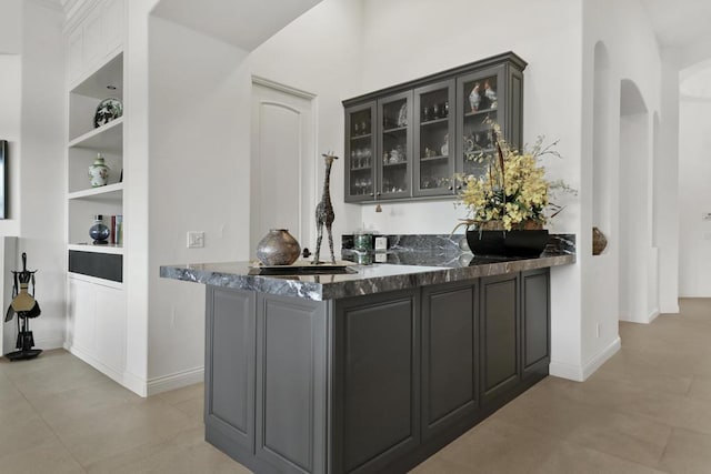 bar featuring built in features and dark stone counters