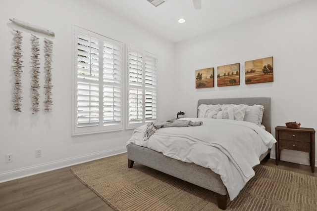 bedroom with multiple windows, dark hardwood / wood-style flooring, and ceiling fan