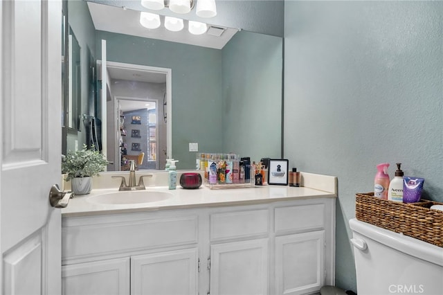 bathroom featuring toilet and vanity