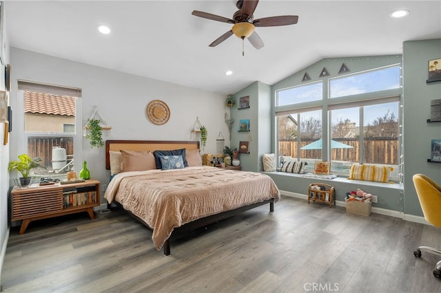 bedroom with ceiling fan, vaulted ceiling, and wood-type flooring