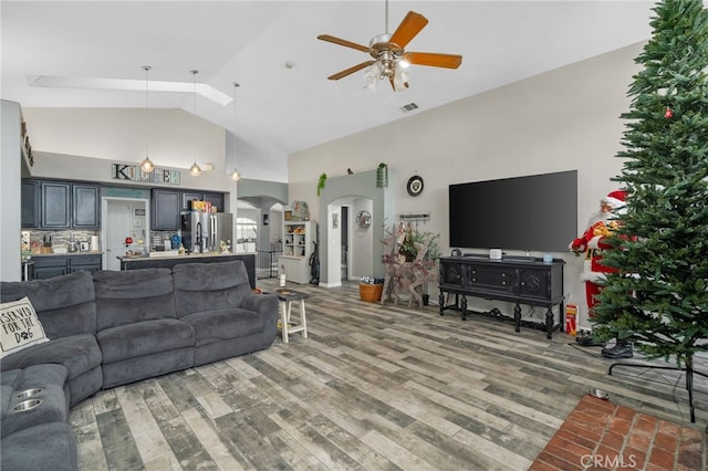 living room with ceiling fan, hardwood / wood-style flooring, and high vaulted ceiling