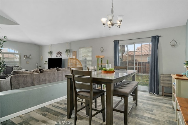 dining space featuring plenty of natural light, hardwood / wood-style floors, and a notable chandelier