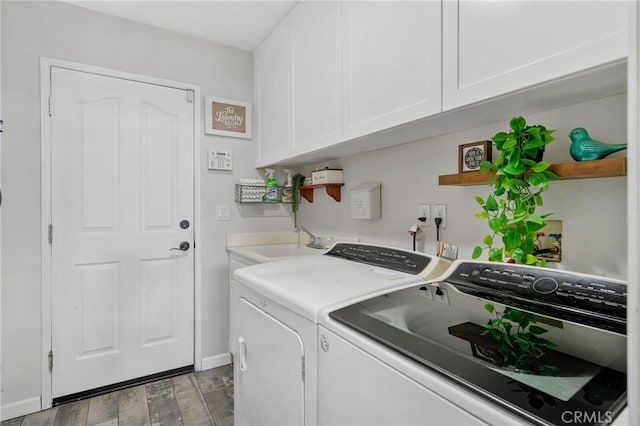 washroom with cabinets, washer and dryer, and sink