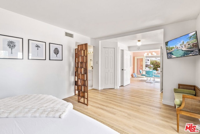 bedroom with a chandelier and light hardwood / wood-style floors