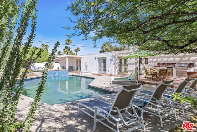 view of swimming pool featuring a patio area, grilling area, and area for grilling