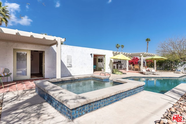 view of pool with a patio and an in ground hot tub