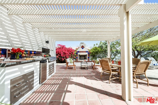 view of patio with exterior kitchen, sink, and a pergola