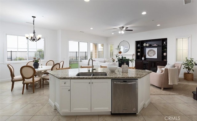 kitchen featuring ceiling fan with notable chandelier, white cabinetry, sink, hanging light fixtures, and light stone counters