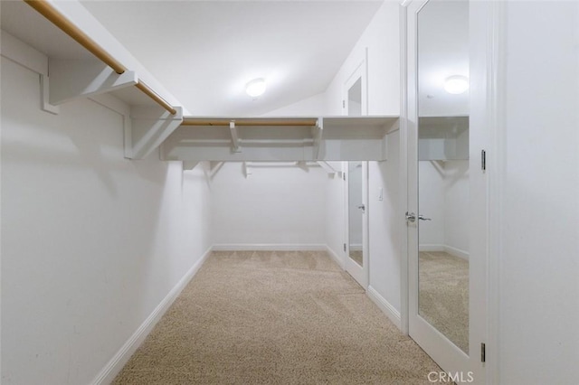 walk in closet featuring light colored carpet