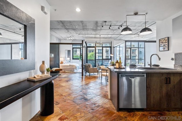 kitchen with decorative light fixtures, sink, dark brown cabinetry, and stainless steel dishwasher