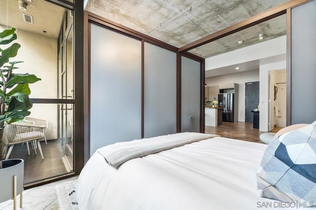 bedroom with stainless steel refrigerator with ice dispenser and a closet