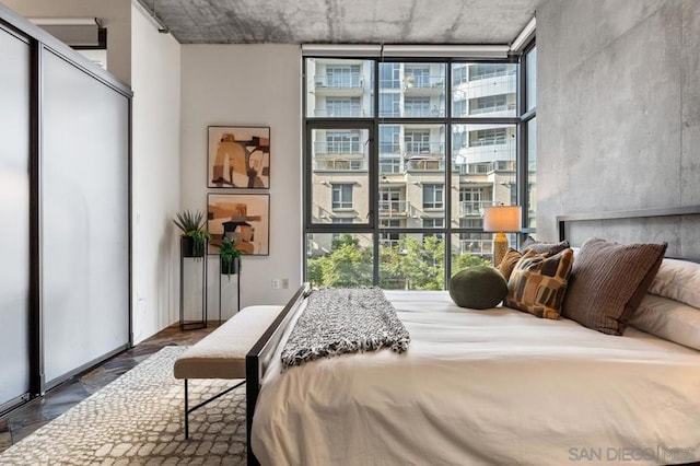 bedroom featuring expansive windows, dark hardwood / wood-style floors, and multiple windows