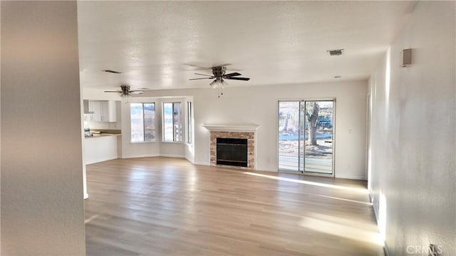 unfurnished living room featuring light hardwood / wood-style floors, a wealth of natural light, and ceiling fan