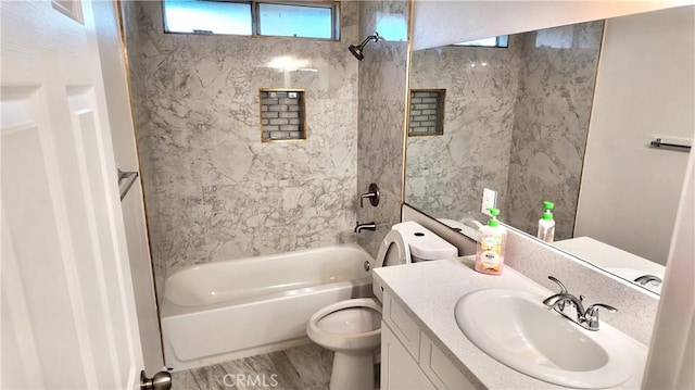 full bathroom with toilet, tiled shower / bath, hardwood / wood-style floors, and vanity