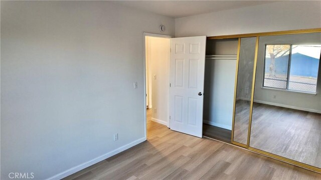 unfurnished bedroom with a closet and light hardwood / wood-style flooring