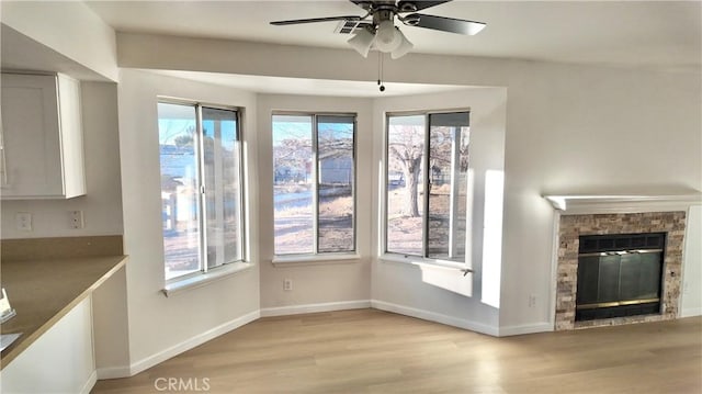 unfurnished living room featuring light hardwood / wood-style floors, ceiling fan, and a healthy amount of sunlight